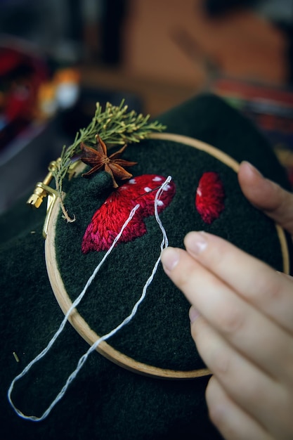 hands embroidering floral pattern